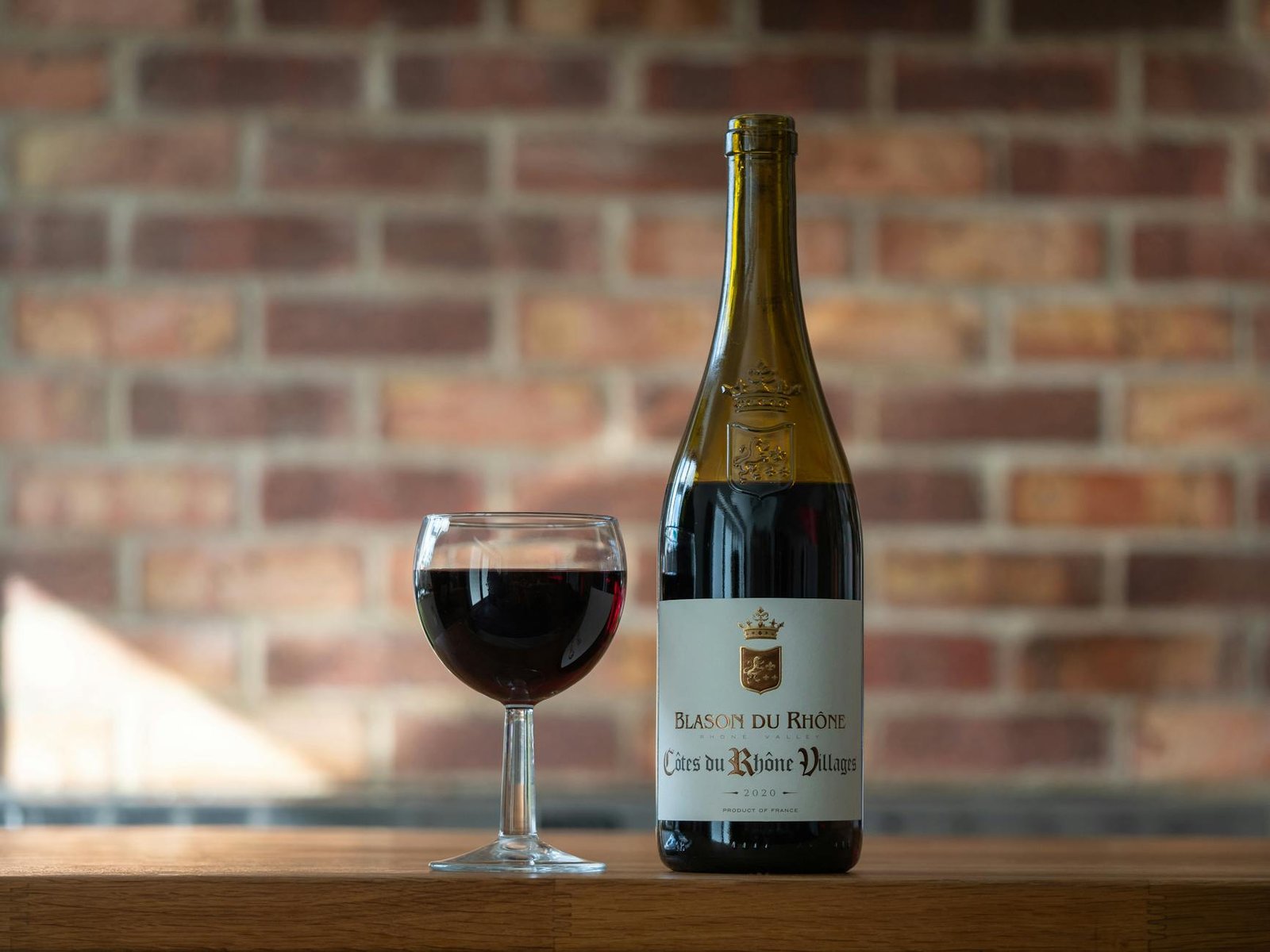 A bottle of wine and a glass of wine on a table