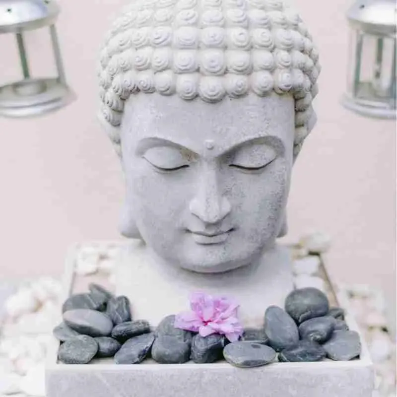 A serene spa setting with a Buddha statue and stones